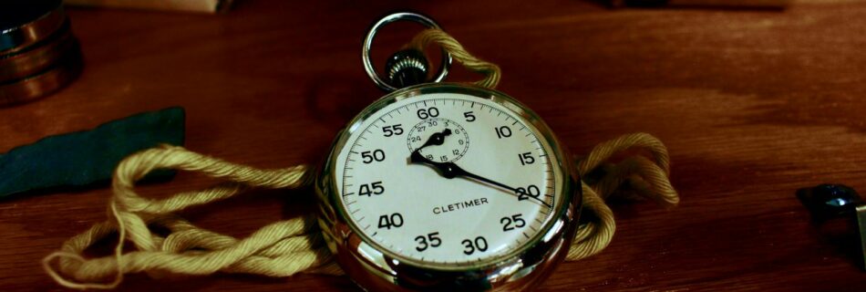 White Pocket Watch With Gold-colored Frame on Brown Wooden Board