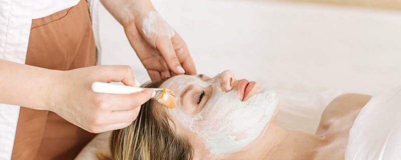 A Woman Lying on Bed Having a Facial Treatment
