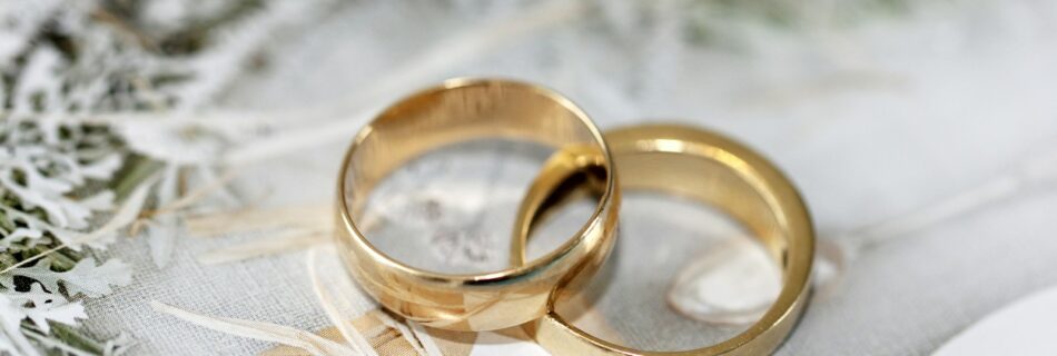 gold wedding band on white textile