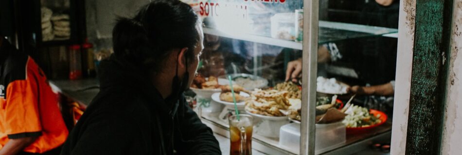 a woman standing in front of a counter filled with food