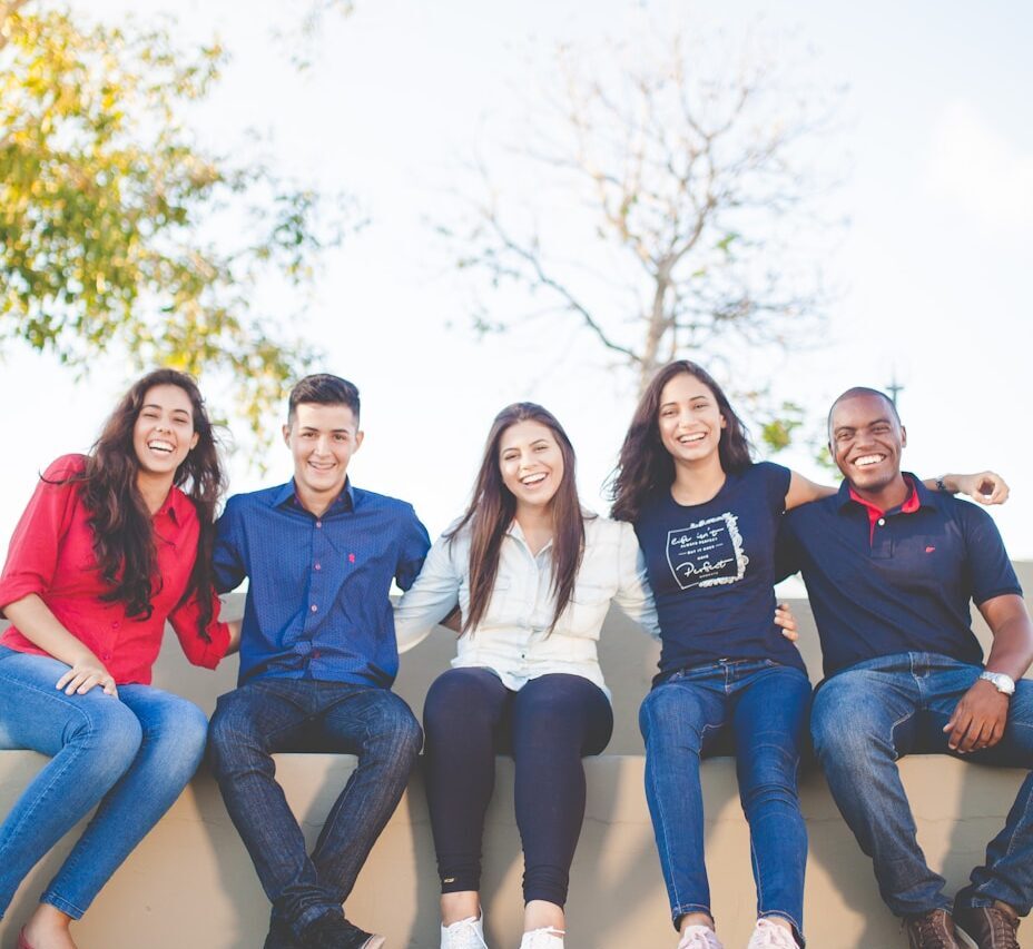 group of people sitting on bench near trees duting daytime