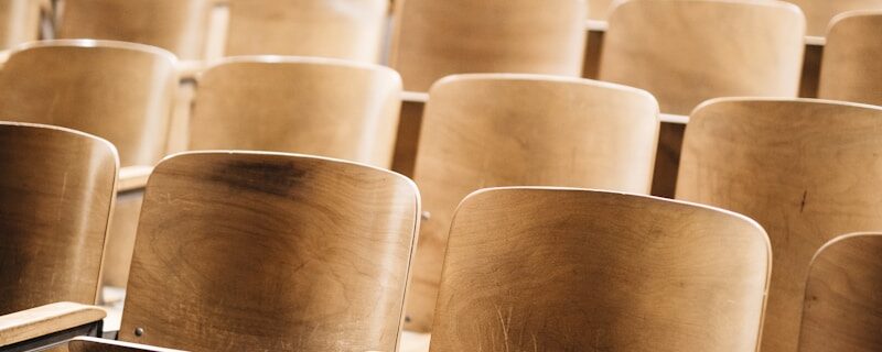 vacant brown wooden chair at stadium